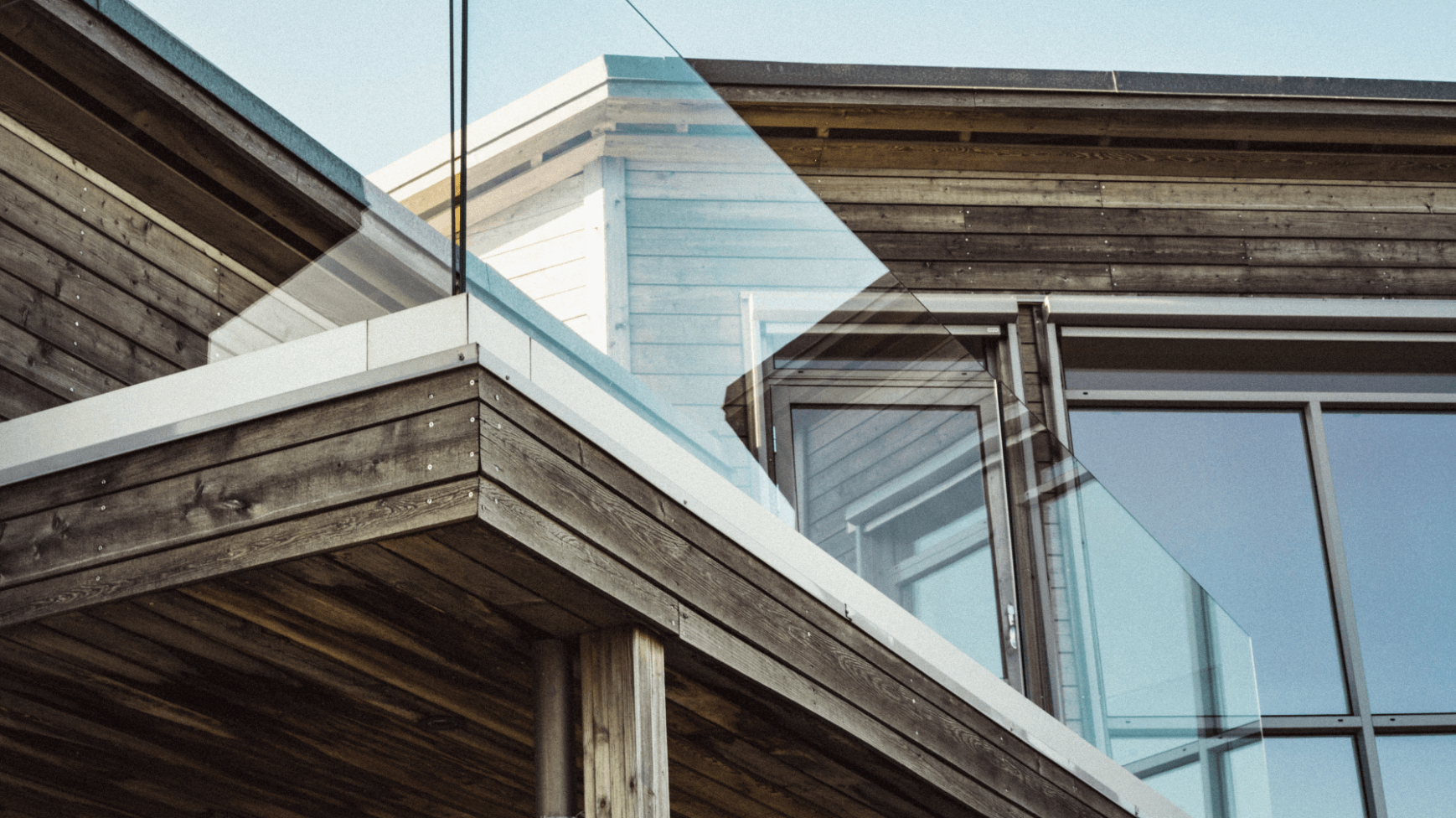 faible-angle-de-vue-d-une-maison-en-bois-moderne-avec-bordures-de-terrasse-en-verre